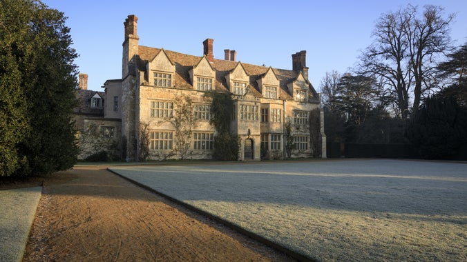A photo of the frosty lawn in front of the house at Anglesey Abbey. Blue skies.